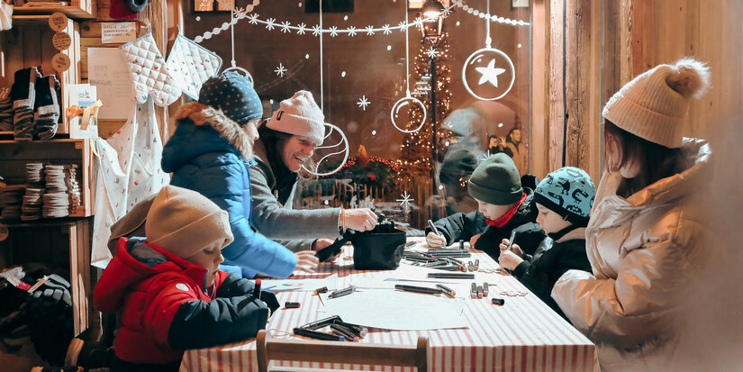Ein weißer Flurbereich mit einer offenen Garderobe, Kissen und einem kleinen schwarzen Schild
