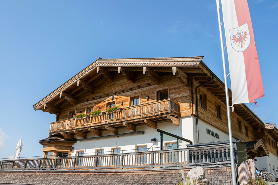 Ein weißer Flurbereich mit einer offenen Garderobe, Kissen und einem kleinen schwarzen Schild