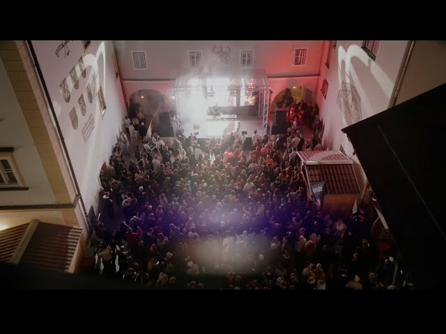 Ein weißer Flurbereich mit einer offenen Garderobe, Kissen und einem kleinen schwarzen Schild