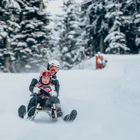 Ein weißer Flurbereich mit einer offenen Garderobe, Kissen und einem kleinen schwarzen Schild