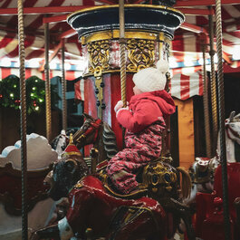 Ein weißer Flurbereich mit einer offenen Garderobe, Kissen und einem kleinen schwarzen Schild