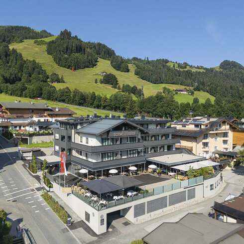 Ein weißer Flurbereich mit einer offenen Garderobe, Kissen und einem kleinen schwarzen Schild
