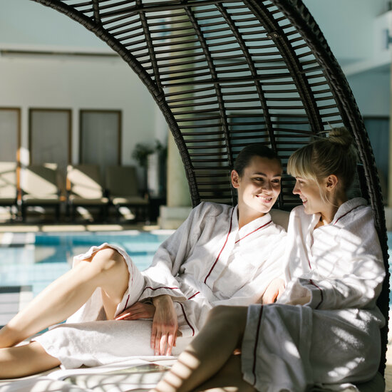 Ein weißer Flurbereich mit einer offenen Garderobe, Kissen und einem kleinen schwarzen Schild