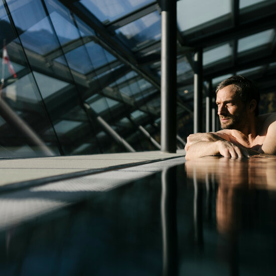 Ein weißer Flurbereich mit einer offenen Garderobe, Kissen und einem kleinen schwarzen Schild