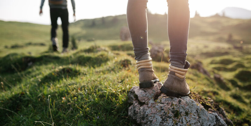 Ein weißer Flurbereich mit einer offenen Garderobe, Kissen und einem kleinen schwarzen Schild
