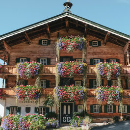 Ein weißer Flurbereich mit einer offenen Garderobe, Kissen und einem kleinen schwarzen Schild