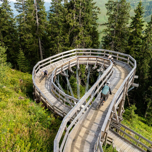 Ein weißer Flurbereich mit einer offenen Garderobe, Kissen und einem kleinen schwarzen Schild