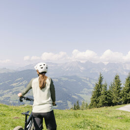 Ein weißer Flurbereich mit einer offenen Garderobe, Kissen und einem kleinen schwarzen Schild