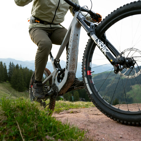 Ein weißer Flurbereich mit einer offenen Garderobe, Kissen und einem kleinen schwarzen Schild
