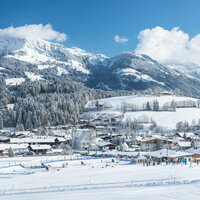 Ein weißer Flurbereich mit einer offenen Garderobe, Kissen und einem kleinen schwarzen Schild