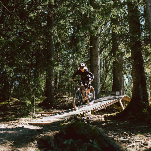 Ein weißer Flurbereich mit einer offenen Garderobe, Kissen und einem kleinen schwarzen Schild