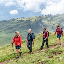 Ein weißer Flurbereich mit einer offenen Garderobe, Kissen und einem kleinen schwarzen Schild