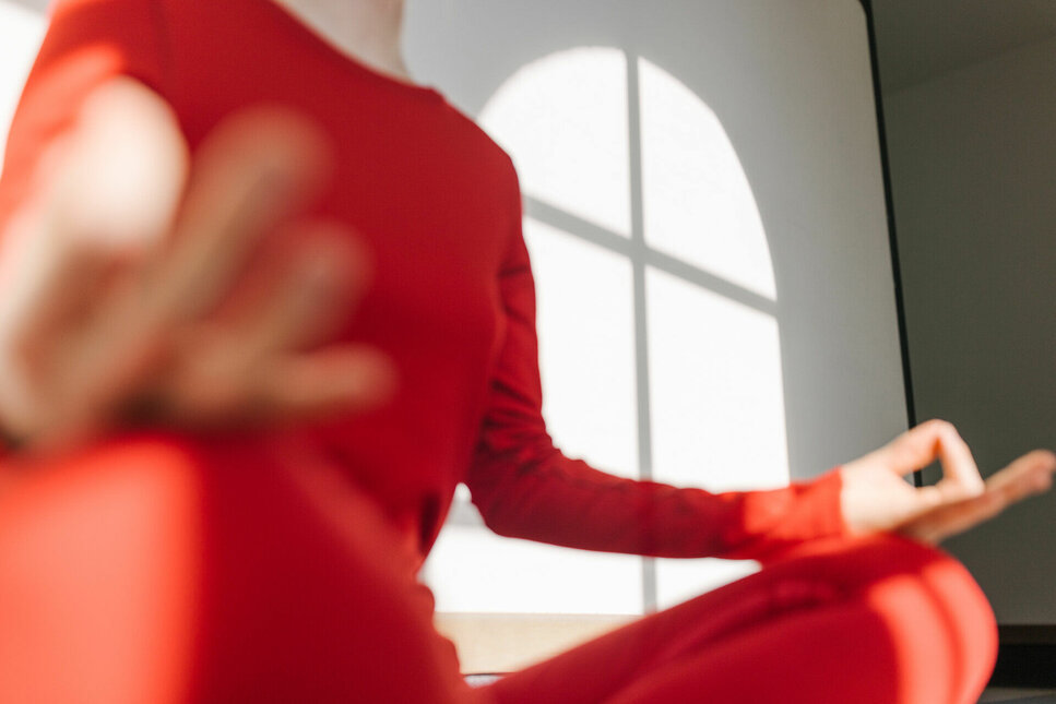 Frau in roter Sportkleidung macht Yoga in Kitzbühel - für Anfänger und Fortgeschrittene