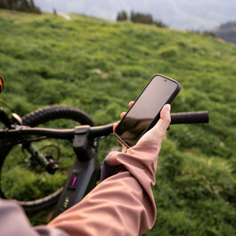 Ein weißer Flurbereich mit einer offenen Garderobe, Kissen und einem kleinen schwarzen Schild