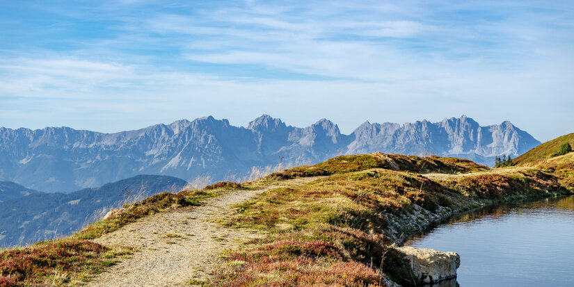 Ein weißer Flurbereich mit einer offenen Garderobe, Kissen und einem kleinen schwarzen Schild