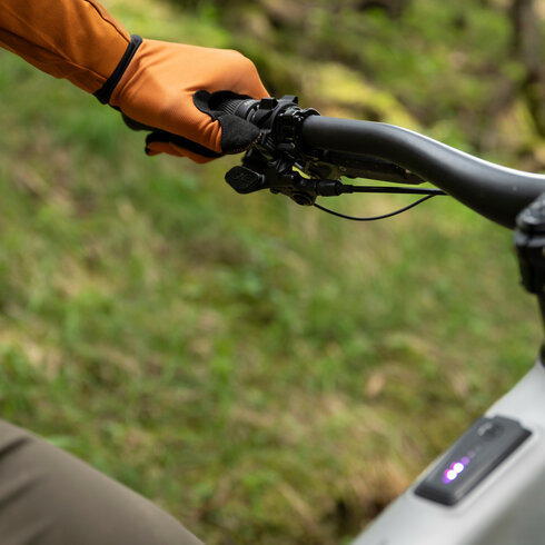 Ein weißer Flurbereich mit einer offenen Garderobe, Kissen und einem kleinen schwarzen Schild