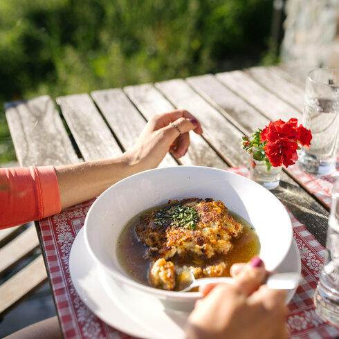 Ein weißer Flurbereich mit einer offenen Garderobe, Kissen und einem kleinen schwarzen Schild