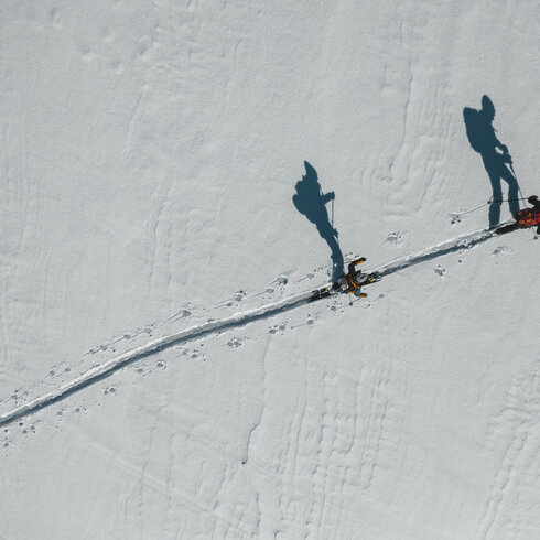 Ein weißer Flurbereich mit einer offenen Garderobe, Kissen und einem kleinen schwarzen Schild