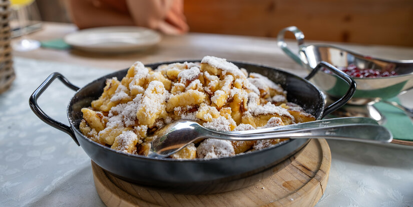 Ein weißer Flurbereich mit einer offenen Garderobe, Kissen und einem kleinen schwarzen Schild
