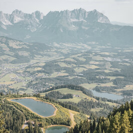 Ein weißer Flurbereich mit einer offenen Garderobe, Kissen und einem kleinen schwarzen Schild