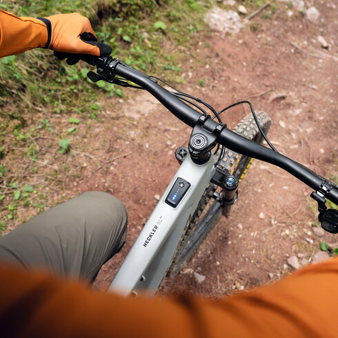 Ein weißer Flurbereich mit einer offenen Garderobe, Kissen und einem kleinen schwarzen Schild