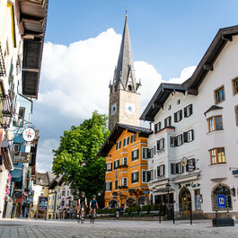 Ein weißer Flurbereich mit einer offenen Garderobe, Kissen und einem kleinen schwarzen Schild
