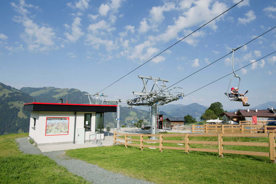 Ein weißer Flurbereich mit einer offenen Garderobe, Kissen und einem kleinen schwarzen Schild