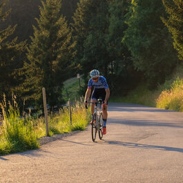 Ein weißer Flurbereich mit einer offenen Garderobe, Kissen und einem kleinen schwarzen Schild