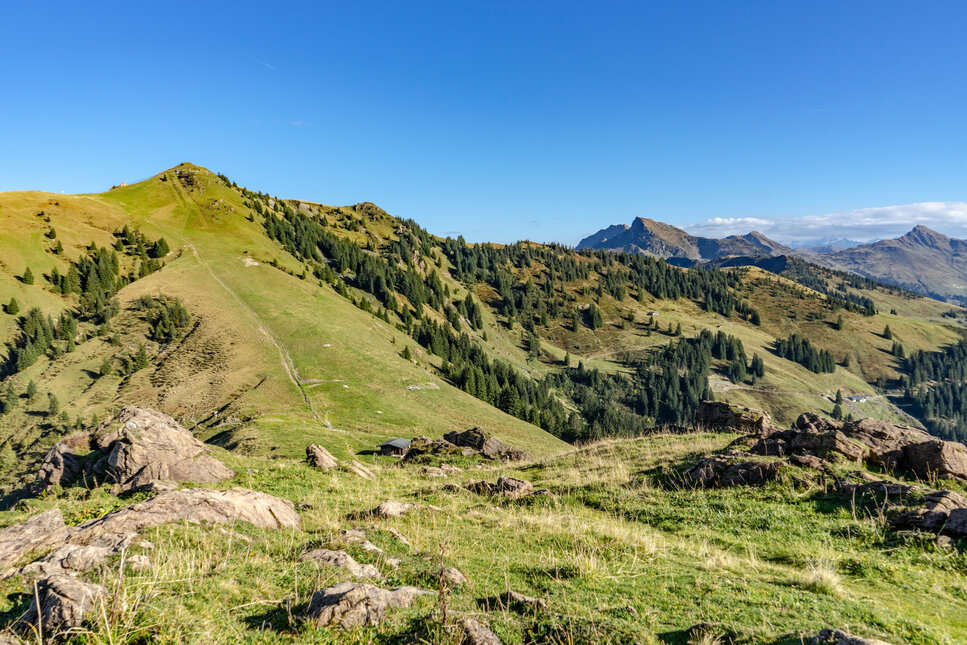 Ein weißer Flurbereich mit einer offenen Garderobe, Kissen und einem kleinen schwarzen Schild