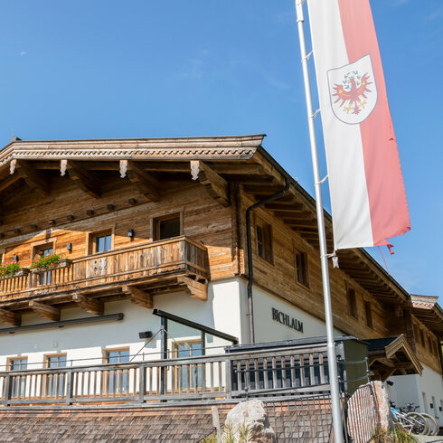 Ein weißer Flurbereich mit einer offenen Garderobe, Kissen und einem kleinen schwarzen Schild