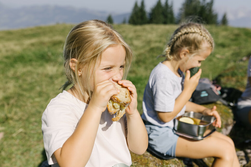 Ein weißer Flurbereich mit einer offenen Garderobe, Kissen und einem kleinen schwarzen Schild