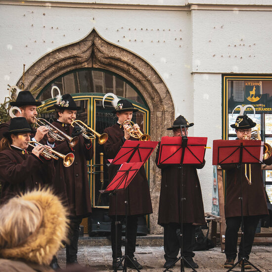 Ein weißer Flurbereich mit einer offenen Garderobe, Kissen und einem kleinen schwarzen Schild