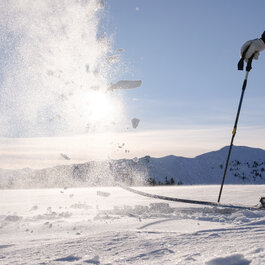 Schnee, der durch einen Ski in die Luft geworfen wird