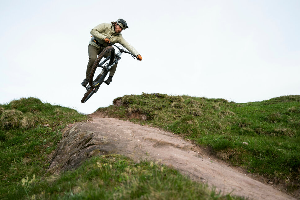 Ein weißer Flurbereich mit einer offenen Garderobe, Kissen und einem kleinen schwarzen Schild