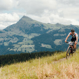 Ein weißer Flurbereich mit einer offenen Garderobe, Kissen und einem kleinen schwarzen Schild