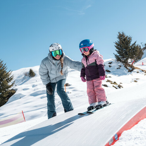 Ein weißer Flurbereich mit einer offenen Garderobe, Kissen und einem kleinen schwarzen Schild