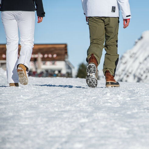 Ein weißer Flurbereich mit einer offenen Garderobe, Kissen und einem kleinen schwarzen Schild