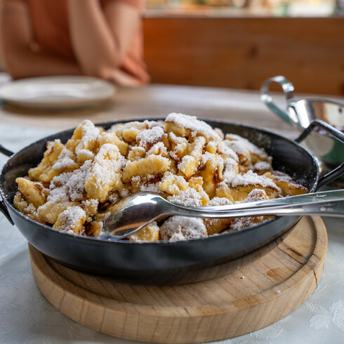 Ein weißer Flurbereich mit einer offenen Garderobe, Kissen und einem kleinen schwarzen Schild
