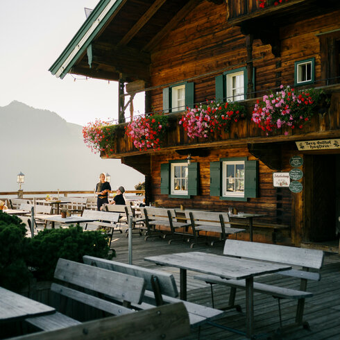 Ein weißer Flurbereich mit einer offenen Garderobe, Kissen und einem kleinen schwarzen Schild