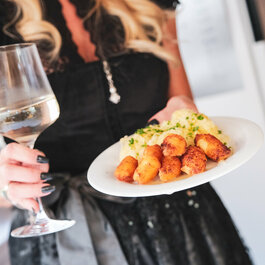 Ein weißer Flurbereich mit einer offenen Garderobe, Kissen und einem kleinen schwarzen Schild