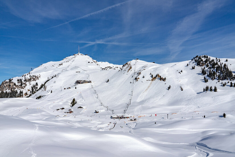 Ein weißer Flurbereich mit einer offenen Garderobe, Kissen und einem kleinen schwarzen Schild