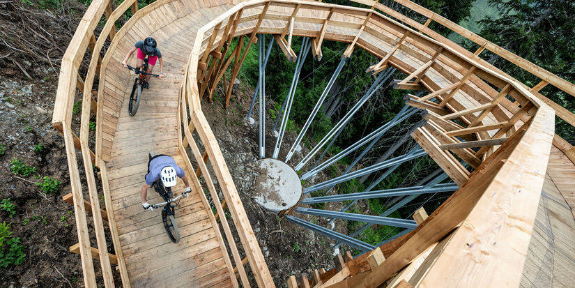Ein weißer Flurbereich mit einer offenen Garderobe, Kissen und einem kleinen schwarzen Schild