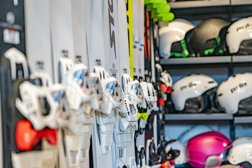 Ein weißer Flurbereich mit einer offenen Garderobe, Kissen und einem kleinen schwarzen Schild