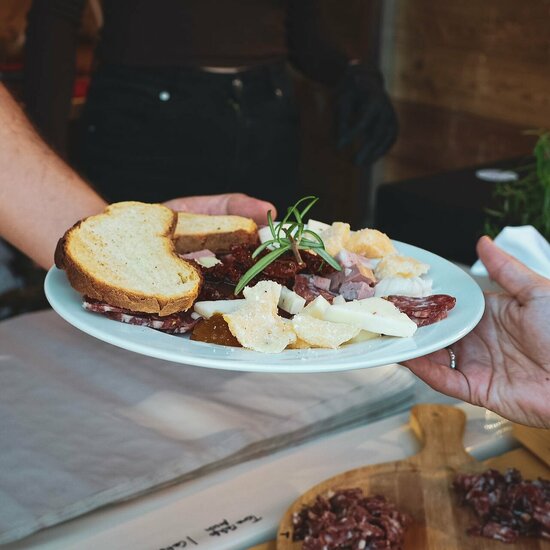 Ein weißer Flurbereich mit einer offenen Garderobe, Kissen und einem kleinen schwarzen Schild