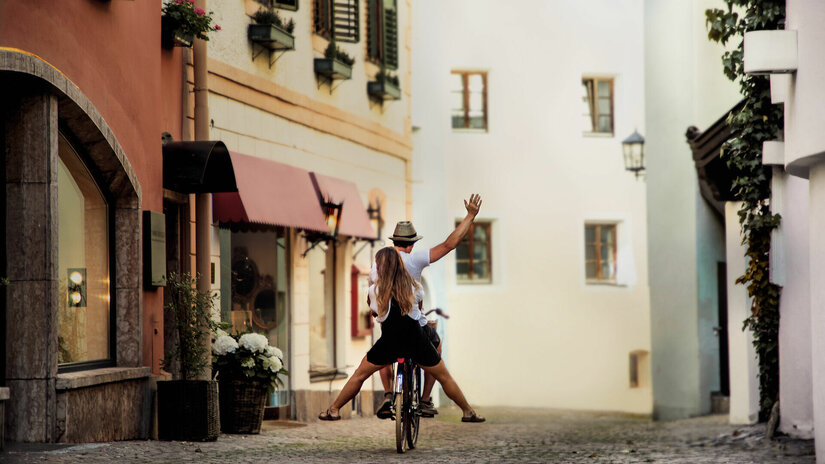 Ein weißer Flurbereich mit einer offenen Garderobe, Kissen und einem kleinen schwarzen Schild