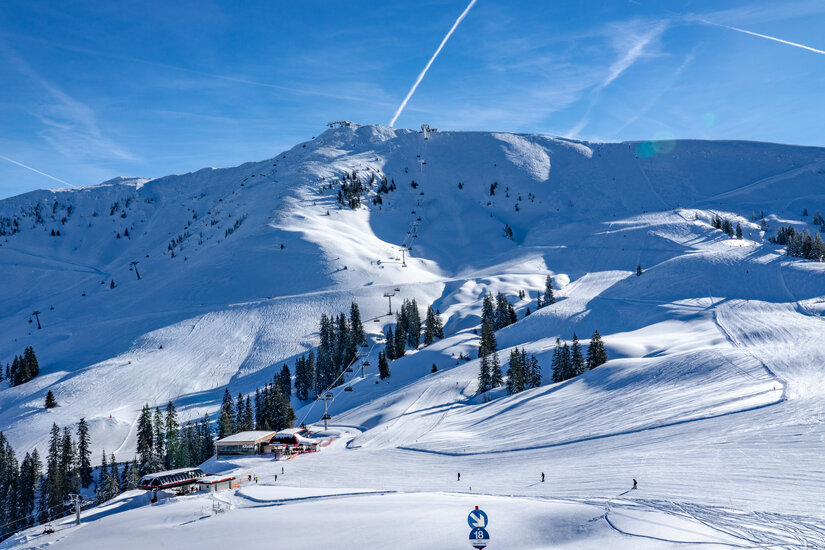 Ein weißer Flurbereich mit einer offenen Garderobe, Kissen und einem kleinen schwarzen Schild