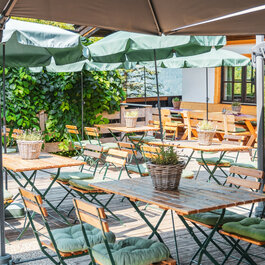 Ein weißer Flurbereich mit einer offenen Garderobe, Kissen und einem kleinen schwarzen Schild