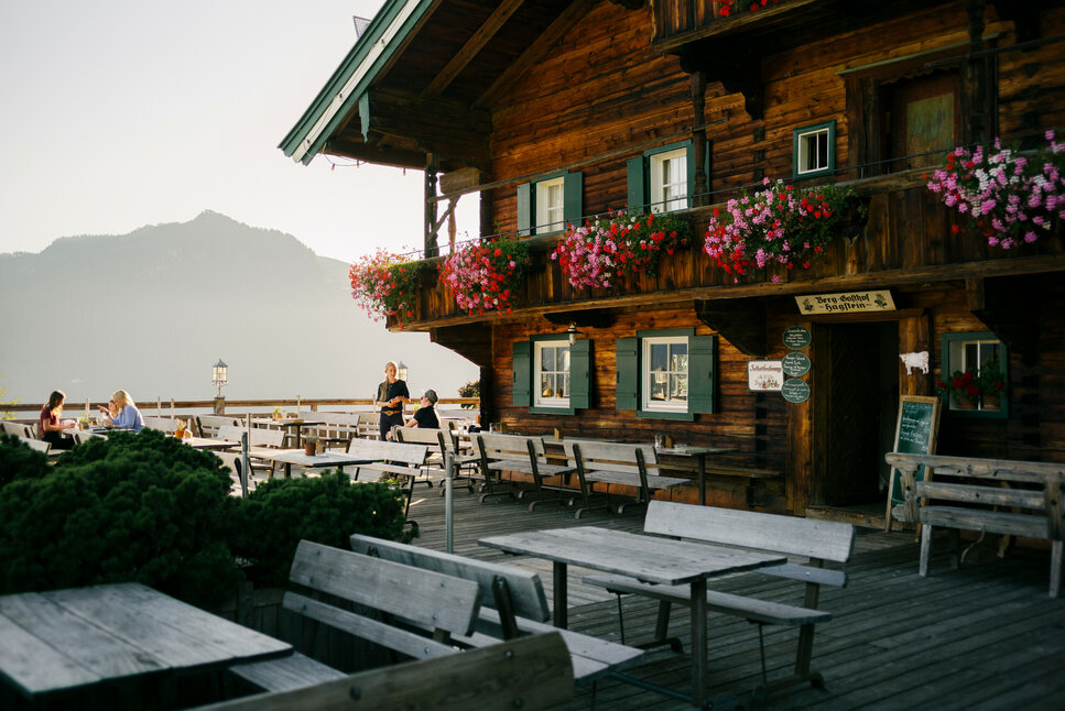 Ein weißer Flurbereich mit einer offenen Garderobe, Kissen und einem kleinen schwarzen Schild