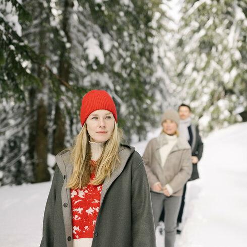 Ein weißer Flurbereich mit einer offenen Garderobe, Kissen und einem kleinen schwarzen Schild