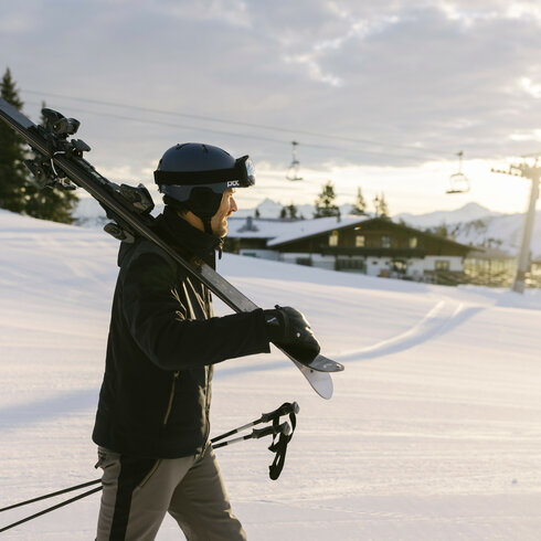 Ein Skifahrer, der Skier trägt